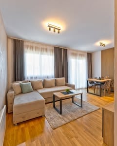 Udoban dnevni boravak apartmana Boréa sa ugaonom garniturom i trpezarijom